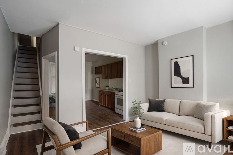A living room with a white couch, a wooden chair, and a coffee table.