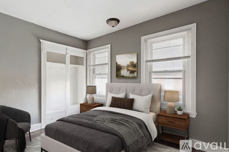 A bedroom with a large bed, a chair, and a painting on the wall.