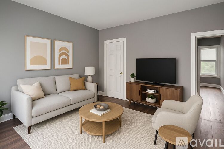 A living room with a white couch, a wooden coffee table, and a television on a wooden stand.