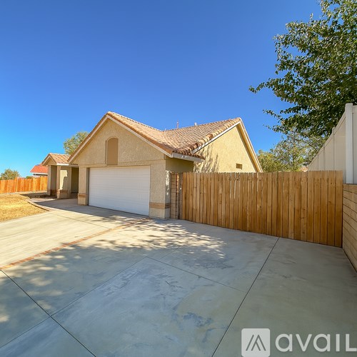 A house with a white garage door and a brown fence.
