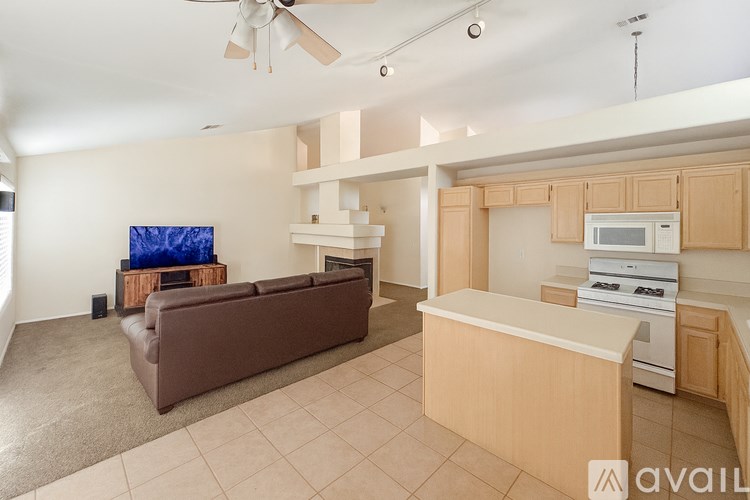 A living room with a brown couch and a ceiling fan.
