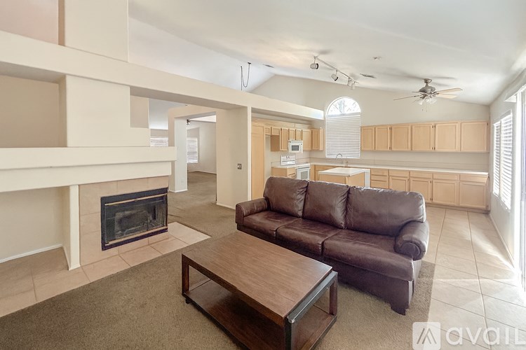 A living room with a brown couch and a fireplace.