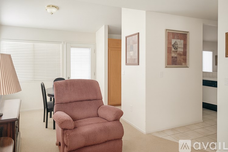 A living room with a red chair and a lamp.