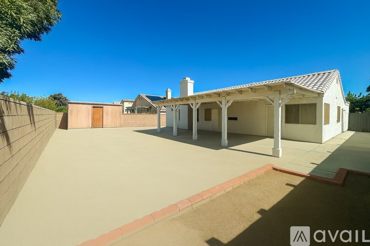 A house with a white roof and a covered patio area is available for rent.