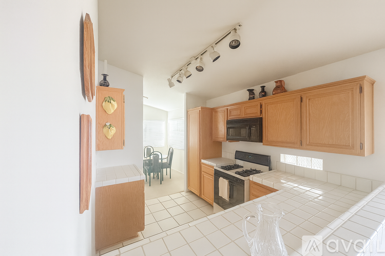 A kitchen with wooden cabinets and a white tiled floor.