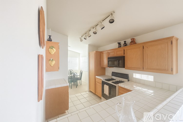 A kitchen with wooden cabinets and a white tiled floor.
