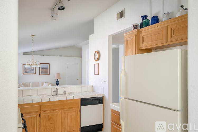 A kitchen with a white fridge and wooden cabinets.