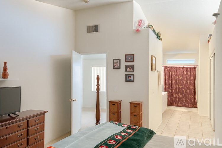 A bedroom with a bed, dresser, and television.