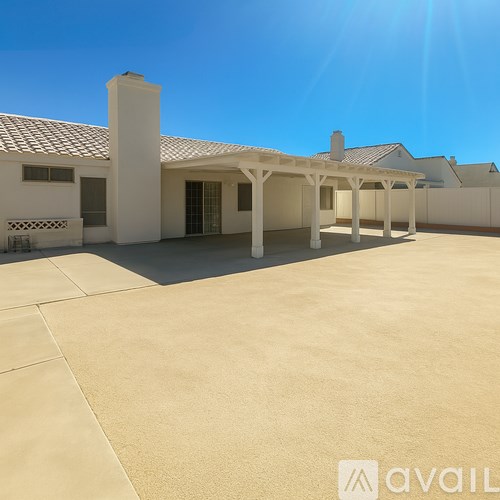 A white building with a tiled roof and a covered patio area.