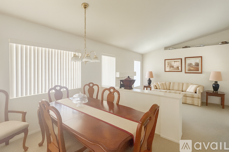 A dining room with a wooden table and chairs.