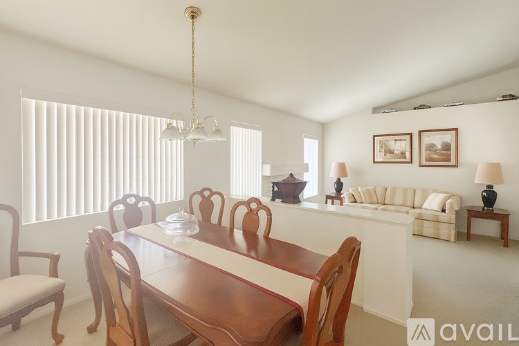 A dining room with a wooden table and chairs.