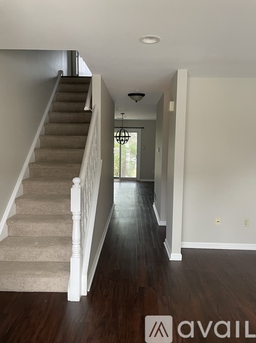 A hallway with a staircase leading to the second floor.