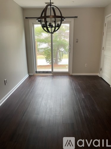 A room with wooden floors and a chandelier.