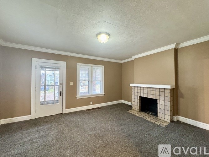A living room with a fireplace and a carpeted floor.