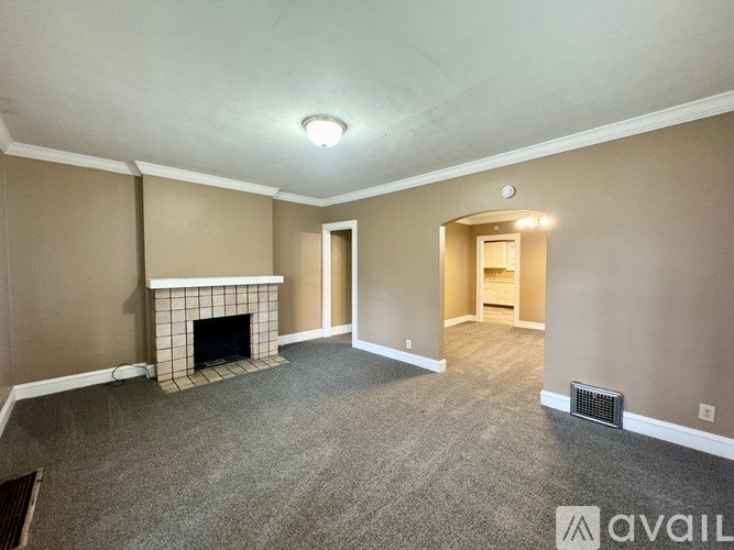 A living room with a fireplace and a carpeted floor.