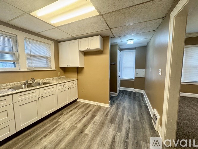 A kitchen with white cabinets and a sink.