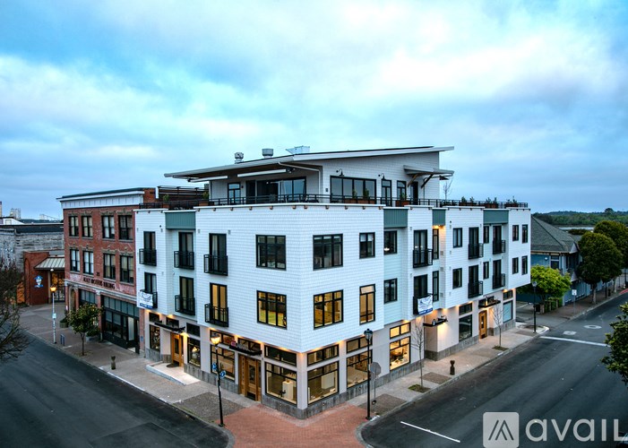 A street view of a multi-story building with a sign that reads "available" in the bottom right corner.