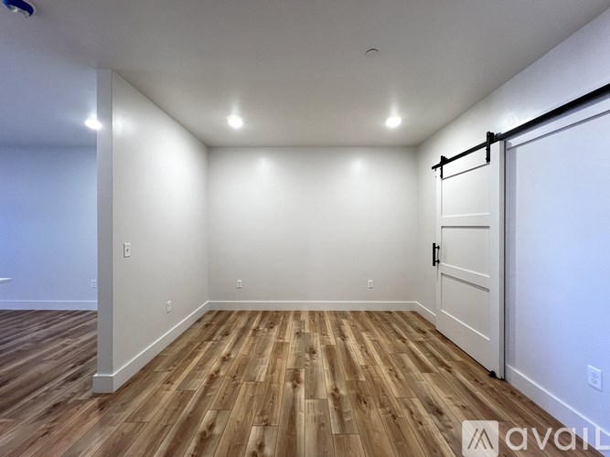 A room with wooden flooring and white walls.