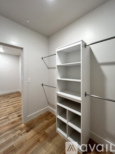 A white closet with shelves and a black rod.