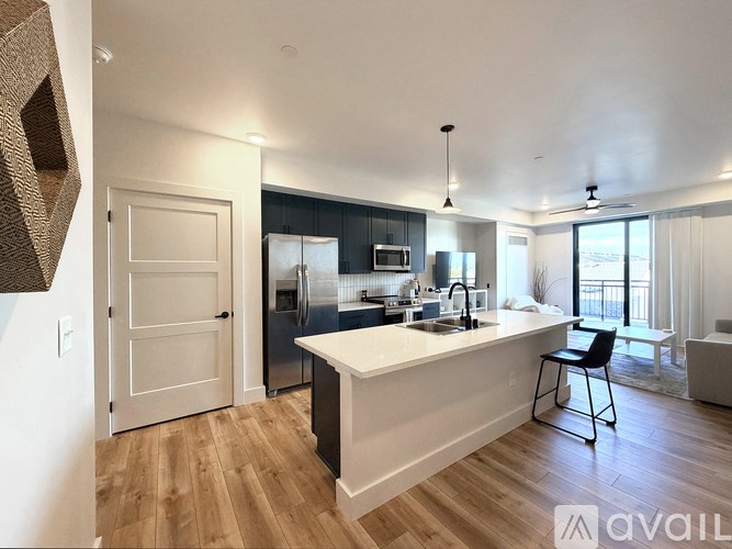 A modern kitchen with a large island and a dining area.