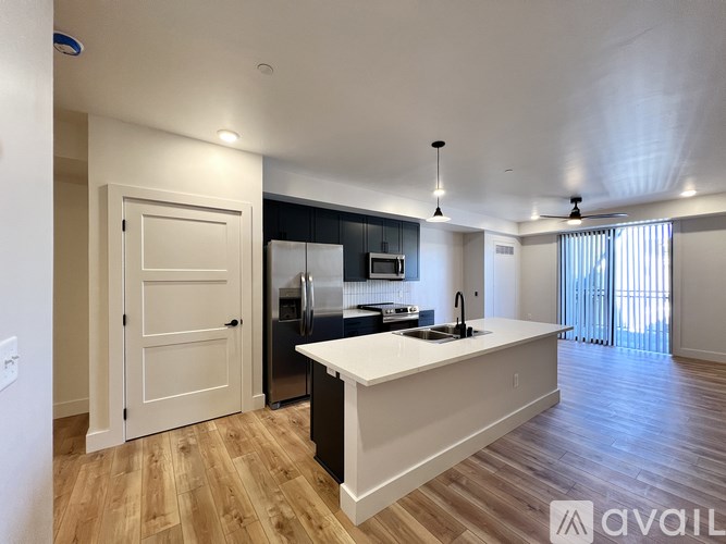 A kitchen with a white island and wooden floors.