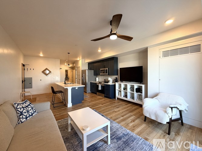 A living room with a couch, a coffee table, and a ceiling fan.