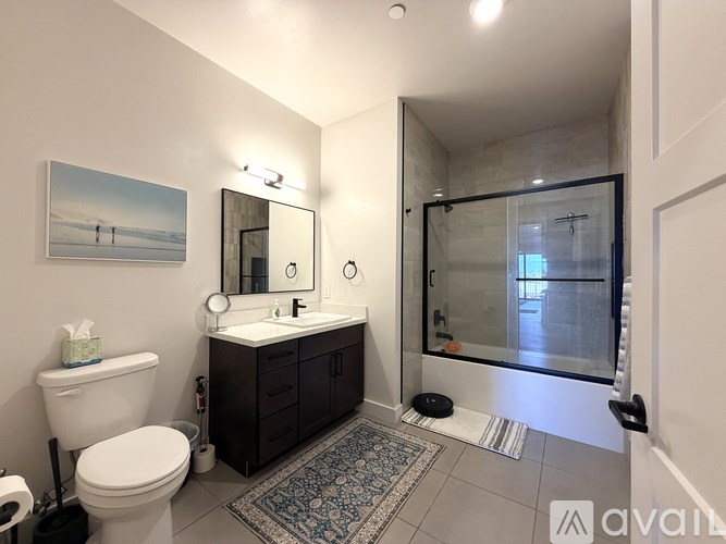 A bathroom with a toilet, sink, and a large mirror.