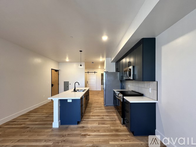 A modern kitchen with dark blue cabinets and a white island.