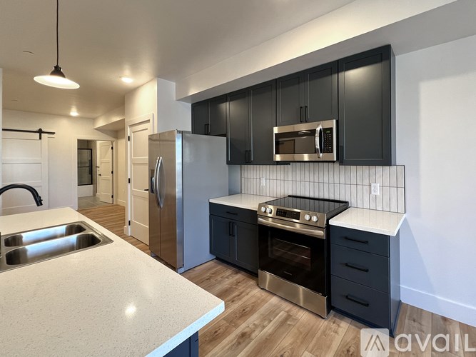 A modern kitchen with a stainless steel refrigerator, oven, and microwave.
