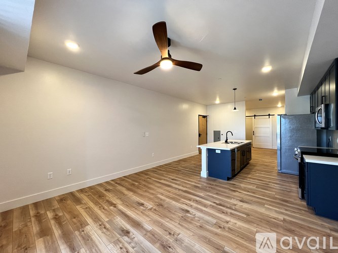 A room with a ceiling fan and wooden flooring.