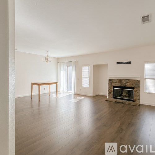 A spacious living room with a fireplace and a dining table.