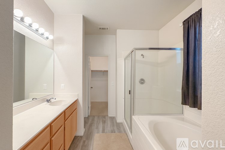 A bathroom with a white sink and a glass shower stall.