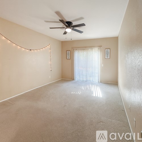 A room with a ceiling fan and a carpeted floor.