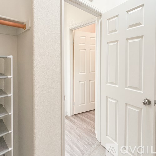 A white door is open to a hallway.