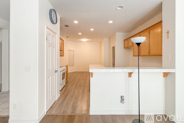 A kitchen with wooden floors and white walls.