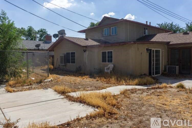 A house with a brown roof and a fence in front of it.