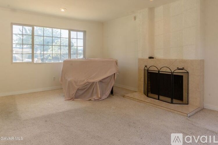 A room with a fireplace and a window covered by a cloth.