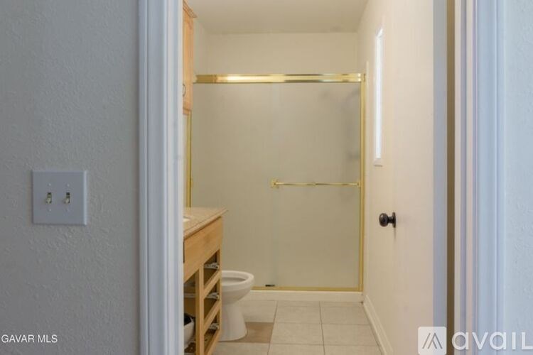 A bathroom with a toilet, sink, and shower.