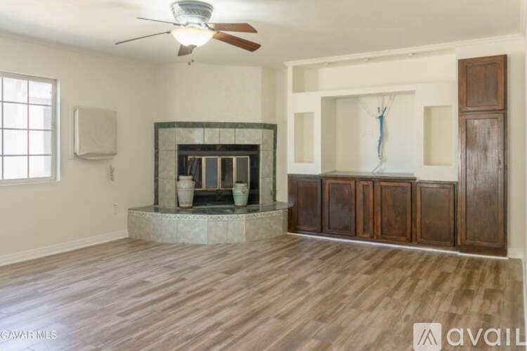 A living room with a fireplace and wood flooring.