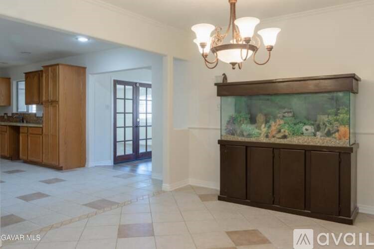 A room with a fish tank and a chandelier.