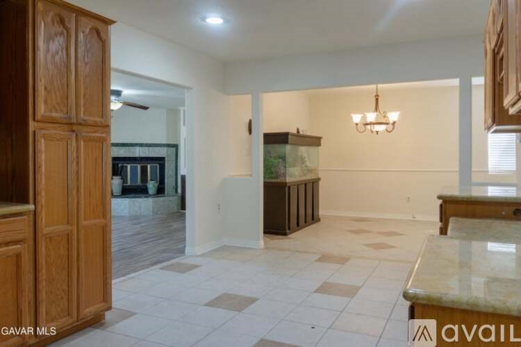 A spacious room with a checkered floor and a chandelier hanging from the ceiling.