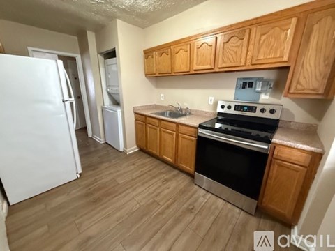 A kitchen with wooden cabinets and a white refrigerator.