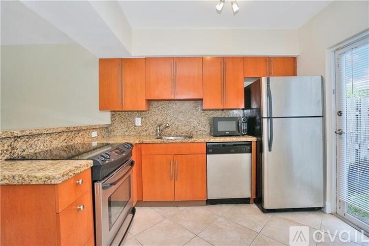 A kitchen with wooden cabinets and granite countertops.