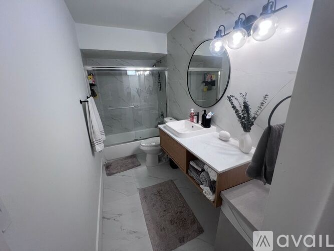 A bathroom with a marble floor and a mirror above the sink.