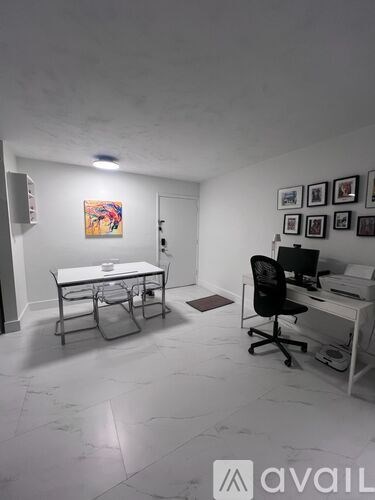 A white room with a desk and chairs.