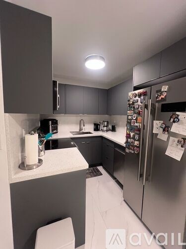 A kitchen with a refrigerator covered in magnets.