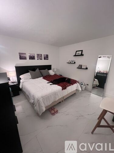 A bedroom with a bed, a chair, and pictures on the wall.