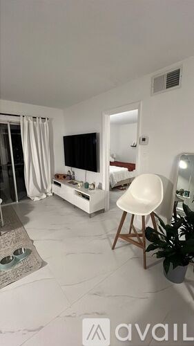 A living room with a white chair and a white sofa.
