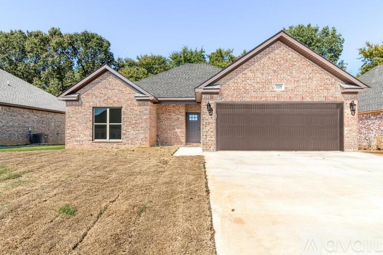 A brick house with a garage door and a driveway in front.