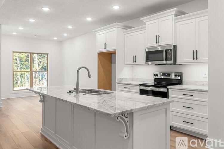 A kitchen with a marble countertop and white cabinets.